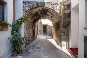 un callejón en un antiguo edificio de piedra con un túnel en Su Nidu Nou, en Dorgali