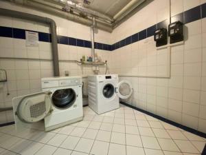 a laundry room with a washing machine and a washer at Gemütliche Wohnung am Golfplatz mit Bergblick in St. Wolfgang