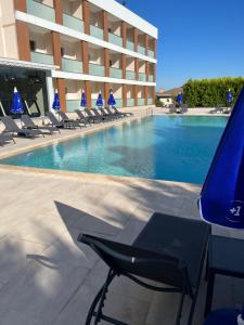 uma piscina com espreguiçadeiras e um hotel em Holiday Inn Express Manisa-West, an IHG Hotel em Manisa