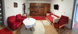 un soggiorno con un divano rosso e 2 sedie di Casa Misha 
