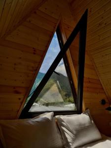 a bedroom with a large window in a cabin at Trip Zone Kazbegi in Kazbegi