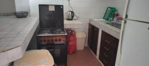 Il comprend une cuisine équipée d'une cuisinière et d'un réfrigérateur. dans l'établissement Holiday studio, à Ukunda