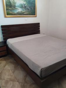 a bed in a bedroom with a picture on the wall at Summer and Winter Villas in Néa Tríglia