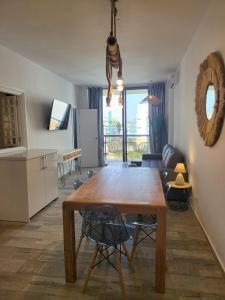 a kitchen and living room with a wooden dining table at Beach Apartment - Benalmadena Costa in Benalmádena