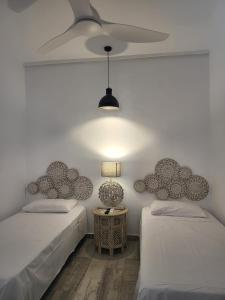 sypialnia z dwoma łóżkami i wentylatorem sufitowym w obiekcie Beach Apartment - Benalmadena Costa w mieście Benalmádena