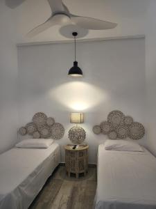a bedroom with two beds and a ceiling fan at Beach Apartment - Benalmadena Costa in Benalmádena