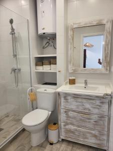 łazienka z toaletą, umywalką i lustrem w obiekcie Beach Apartment - Benalmadena Costa w mieście Benalmádena