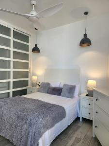 sypialnia z białym łóżkiem i 2 lampami w obiekcie Beach Apartment - Benalmadena Costa w mieście Benalmádena