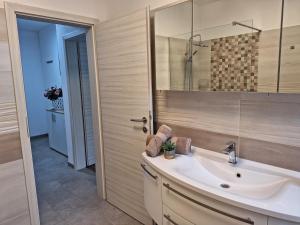 a bathroom with a sink and a mirror at Val&Sol Apartments in Sečovlje +24 photos