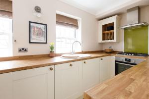 a kitchen with white cabinets and a sink at Castle Bank Terrace in Lewes