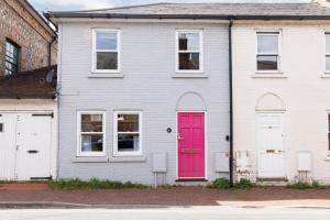 a white house with a pink door at Castle Bank Terrace in Lewes