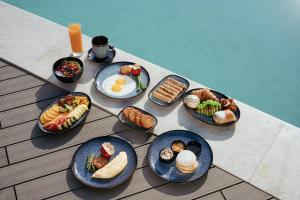 a group of plates of food on a table at Courtyard by Marriott Aravali Resort in Faridabad