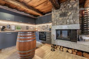 une cuisine avec une cheminée en pierre et un bar dans l'établissement Vineyard Cottage Lan On The Hill - Happy Rentals, à Semič