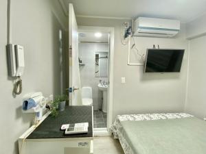 a small room with a bed and a bathroom at JIBIDA Urban Inn in Seoul