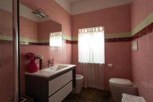 a pink bathroom with a sink and a toilet at Palazzo Monterone in Forio d'Ischia +80 photos
