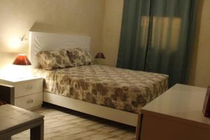ein Schlafzimmer mit einem Bett und eine Kommode mit einer Lampe in der Unterkunft Magnifique villa à Marrakech in Marrakesch