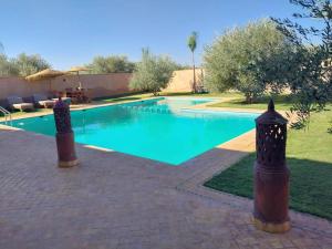 - une piscine d'eau bleue dans la cour dans l'établissement Magnifique villa à Marrakech, à Marrakech