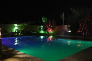 - une piscine éclairée la nuit dans l'établissement Magnifique villa à Marrakech, à Marrakech