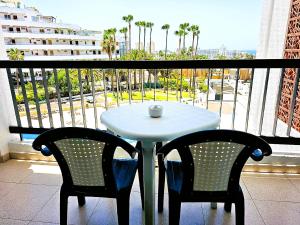 d'une table blanche et de deux chaises sur un balcon. dans l'établissement Viñas del Mar with Sea View, à Playa de las Americas