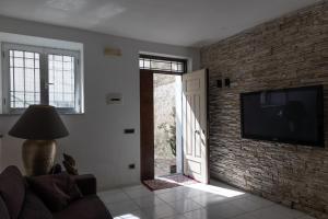 a living room with a television and a brick wall at Palazzo Monterone in Forio d'Ischia