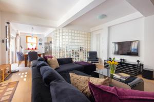 a living room with a couch and a tv at Regency Stables in Brighton & Hove