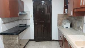 a kitchen with a brown door in a room at Hospital ng Manila front delux le mirage de malate in Manila