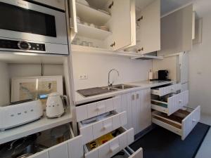 a kitchen with white cabinets and a sink at Casa Atlântico Carvalhal Comporta, apartamento piscina aquecida in Carvalhal