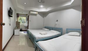 2 camas individuais num quarto com uma televisão em PSD Hotel em Chiang Mai