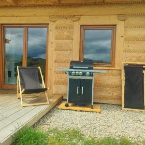 une cuisinière et une chaise en face d'une cabine dans l'établissement Grojcówka, à Żywiec