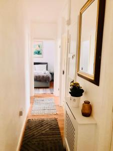 a hallway with a mirror and a room with a bed at City location- 2 bedroom apartment in London