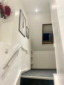 escalera blanca con espejo y TV en Solomons Peak Apartment, en Buxton