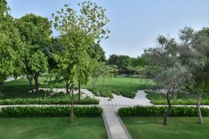 un giardino con scale bianche, alberi e erba di Courtyard by Marriott Aravali Resort a Faridabad