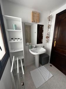 Baño blanco con lavabo y espejo en Casa Lotus, en Altea
