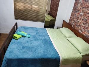 a bedroom with a bed with a blue comforter at Casa, para máximo 6 personas in Melo