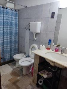 a bathroom with a toilet and a sink at Casa, para máximo 6 personas in Melo