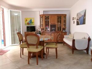 - un salon avec une table à manger et des chaises dans l'établissement casa Maris, à Taviano