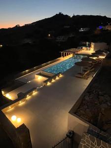 uma piscina com luzes no lado de um edifício em Blue Sky em Ios Chora