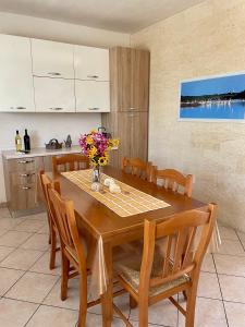 a dining room table with chairs and a vase of flowers on it at Villetta Giada in San Pietro in Bevagna