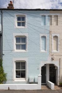 um edifício de tijolos azuis com janelas brancas numa rua em The Pride em Worthing