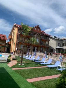 a row of lounge chairs in front of a hotel at Hypnotic Villa Pitesti in Piteşti