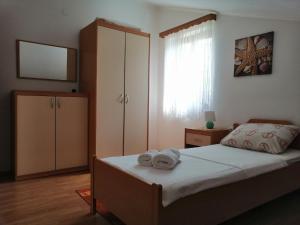 a bedroom with a bed with two towels on it at Apartments Nice View in Krk