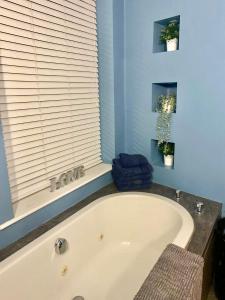 a bath tub in a bathroom with a window at Solomons Peak Apartment in Buxton