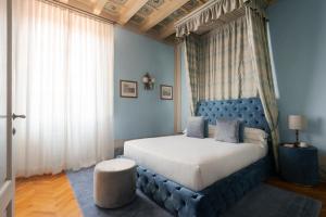 a bedroom with a large bed with a blue headboard at Loggiato Dei Serviti in Florence