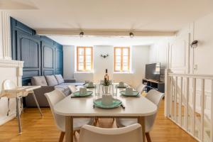 a dining room and living room with a table and chairs at Le Petit Pirou # Cosy # Halte Auvergne in Thiers
