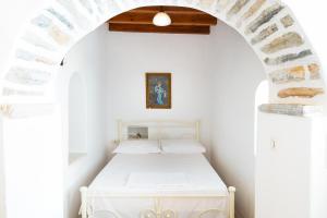 1 dormitorio con 1 cama en una pared blanca en Zeus House en Filótion