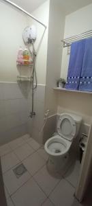 uma casa de banho com um WC branco e uma toalha azul em JJMC PLACE 22f em Manila