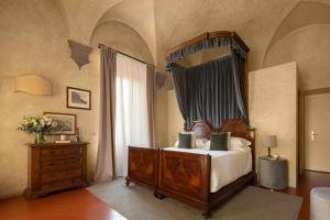 una camera con letto, cassettiera e specchio di Loggiato Dei Serviti a Firenze