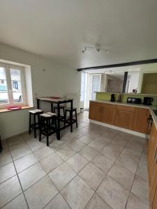 une cuisine avec une table et quelques chaises dans l'établissement Maison de bourg, à Suèvres