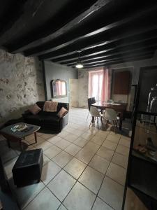 un salon avec un canapé et une table dans l'établissement Maison de bourg, à Suèvres