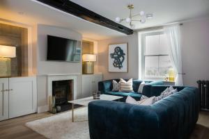 a living room with a blue couch and a fireplace at The Bakery in Arundel